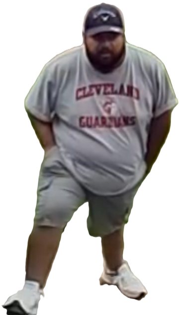 Full-length photograph of Joseph Tennis standing outdoors on a residential walkway, wearing a dark backwards baseball cap, a light Cleveland Guardians T-shirt, grey shorts and white trainers.