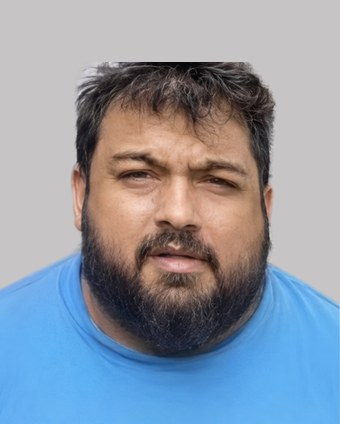 Computer-generated image of Joseph Tennis with dark hair and a full beard, wearing a blue T-shirt, front facing, plain grey background.